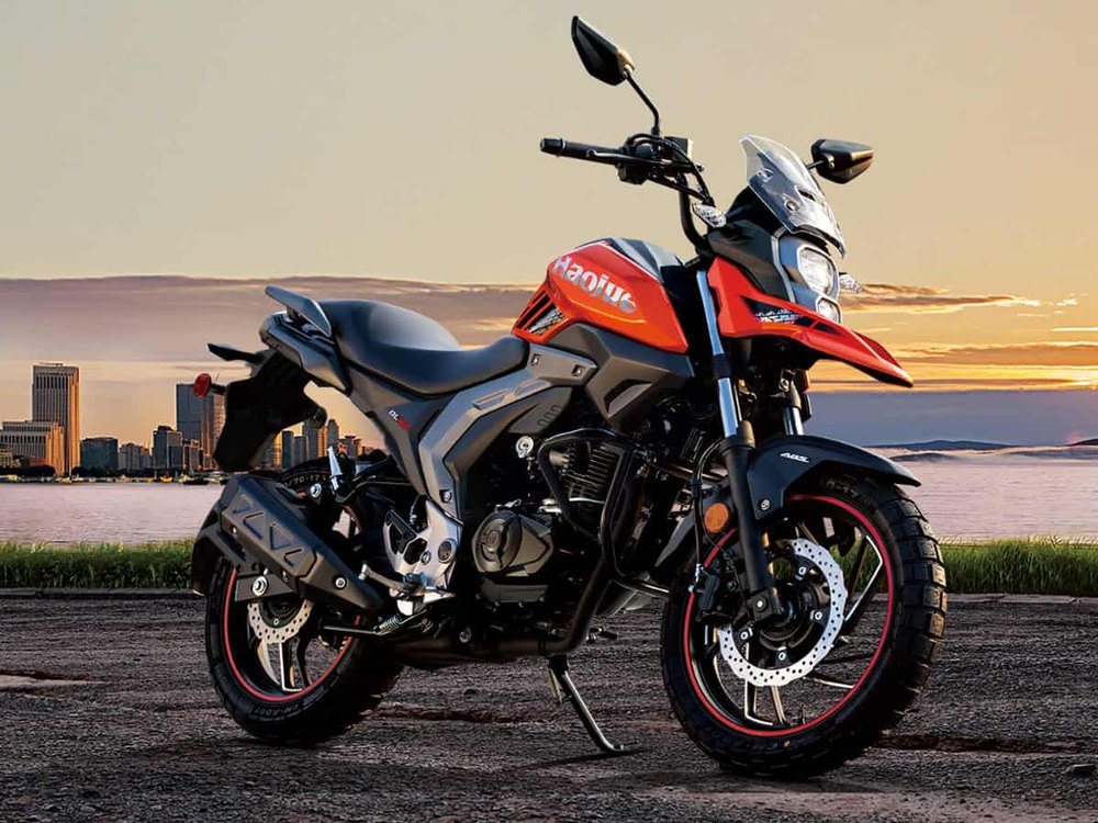 Motocicleta Haojue DL160 frente a la ciudad al atardecer